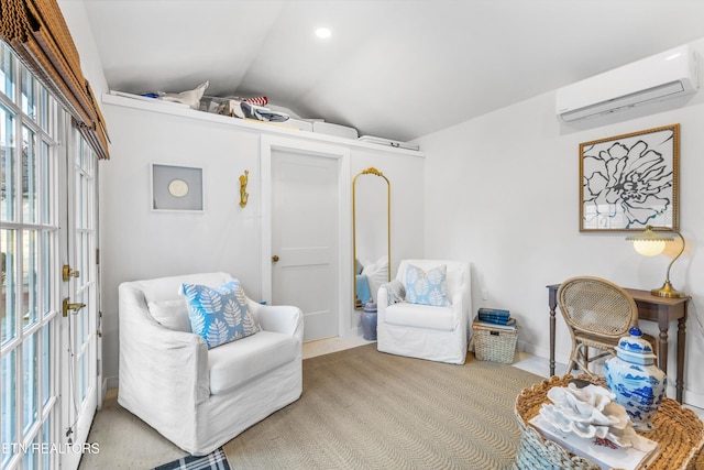 sitting room featuring lofted ceiling and a wall unit AC