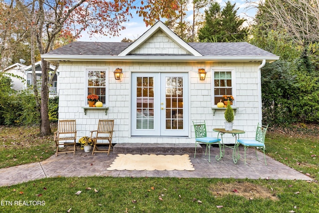 view of outdoor structure featuring a yard and french doors