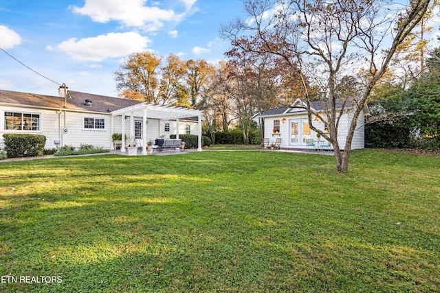 view of yard featuring an outbuilding, a pergola, and a patio area