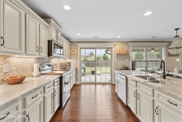 kitchen featuring decorative light fixtures, stainless steel appliances, plenty of natural light, and dark wood-type flooring