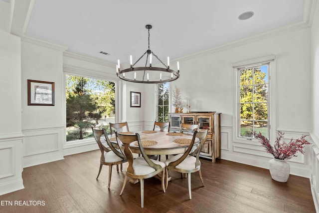 dining room with dark hardwood / wood-style flooring, a chandelier, and crown molding