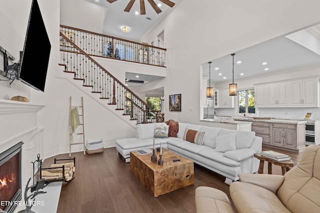 living room with a high ceiling, dark hardwood / wood-style floors, and ornamental molding