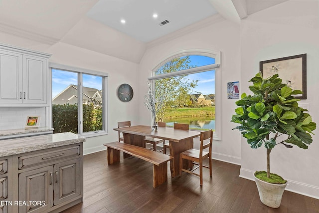 dining space with crown molding, a water view, and dark hardwood / wood-style flooring