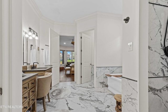 bathroom featuring tile walls, a bathtub, vanity, ceiling fan, and crown molding