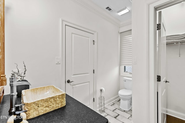 bathroom with toilet, tile patterned flooring, and crown molding