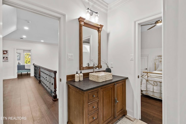 bathroom featuring crown molding, vanity, hardwood / wood-style floors, decorative columns, and ceiling fan