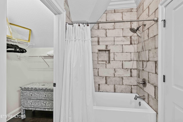 bathroom featuring ornamental molding, a textured ceiling, and shower / bath combo with shower curtain