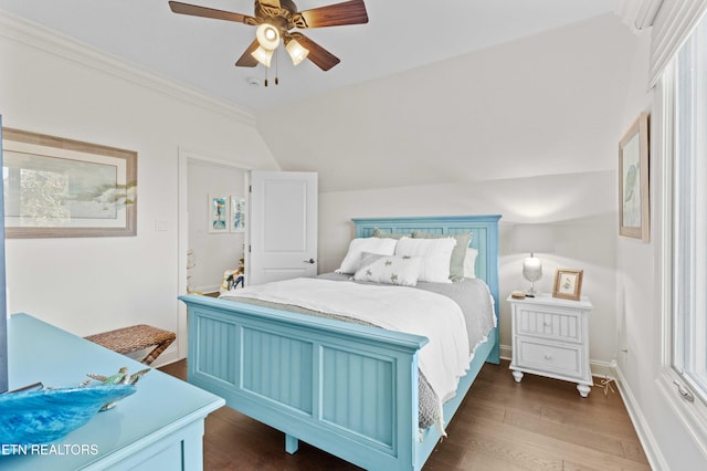 bedroom featuring dark wood-type flooring, ornamental molding, vaulted ceiling, and ceiling fan