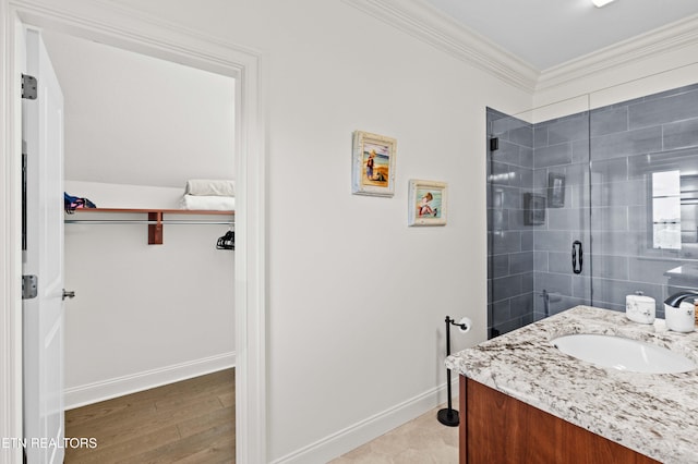 bathroom featuring vanity, hardwood / wood-style floors, ornamental molding, and a shower with shower door