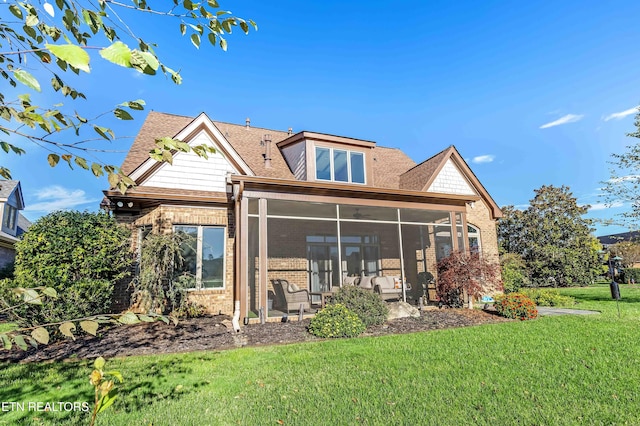 rear view of property featuring a lawn and a sunroom