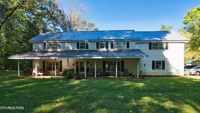 back of property with a patio area and a lawn