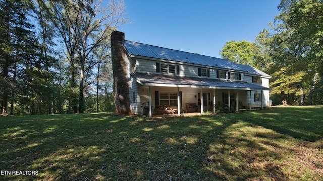 rear view of property with a patio and a lawn