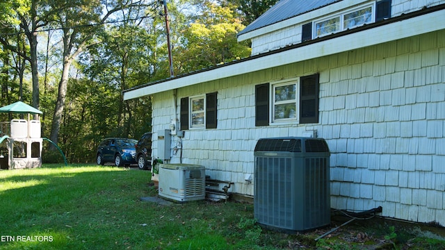 view of side of home featuring central AC and a yard