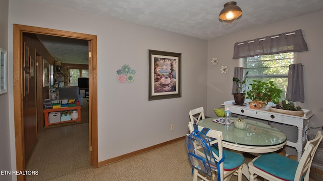 dining space featuring a textured ceiling and light carpet