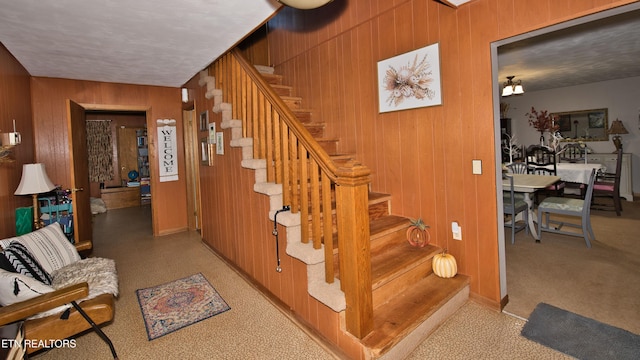 stairs featuring wood walls