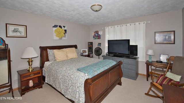 bedroom featuring a textured ceiling and light carpet