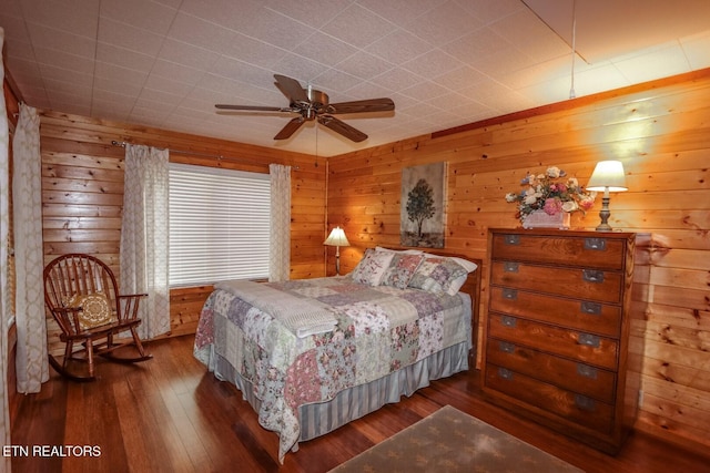 bedroom featuring dark wood-type flooring, ceiling fan, and wood walls