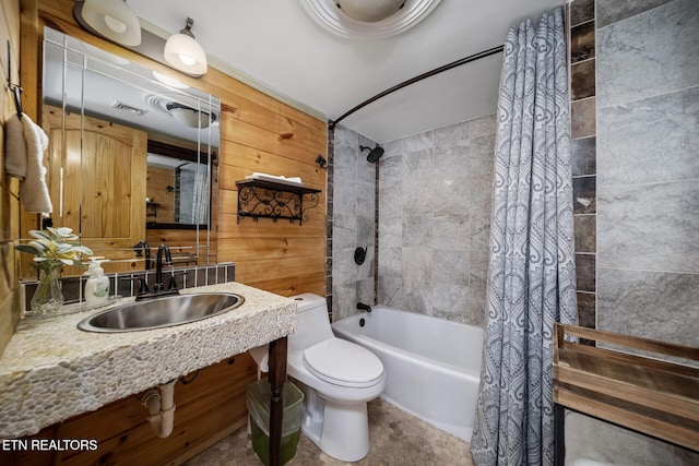 full bathroom with toilet, wood walls, shower / bath combination with curtain, and sink