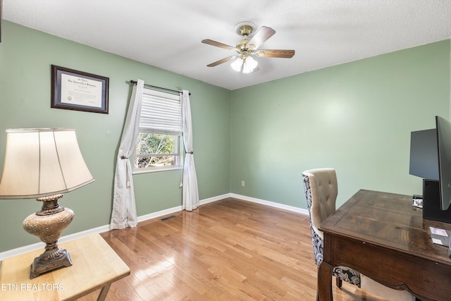 office featuring a textured ceiling, light hardwood / wood-style floors, and ceiling fan