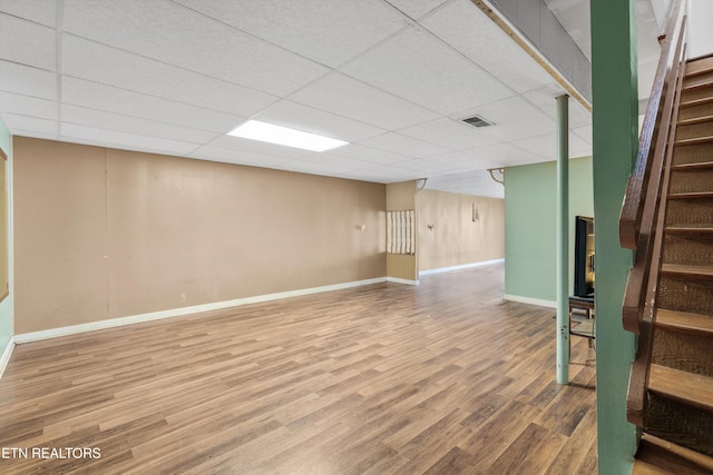 basement featuring hardwood / wood-style floors and a drop ceiling