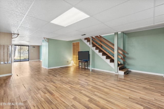 basement featuring hardwood / wood-style floors and a drop ceiling