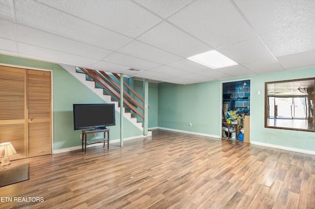 unfurnished living room with a paneled ceiling and hardwood / wood-style flooring