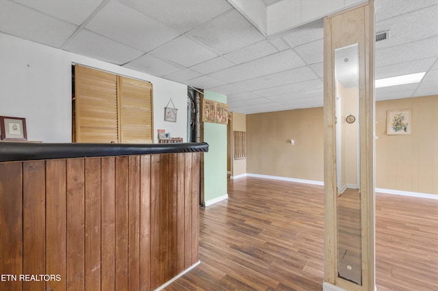 bar featuring a paneled ceiling and hardwood / wood-style floors