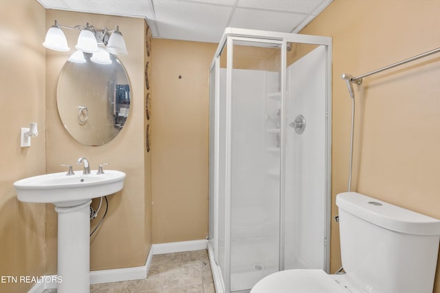 bathroom featuring a paneled ceiling, tile patterned flooring, an enclosed shower, and toilet