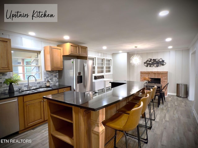 kitchen featuring a breakfast bar, a center island, sink, hardwood / wood-style flooring, and stainless steel appliances