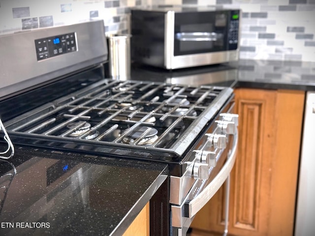 kitchen with appliances with stainless steel finishes and backsplash