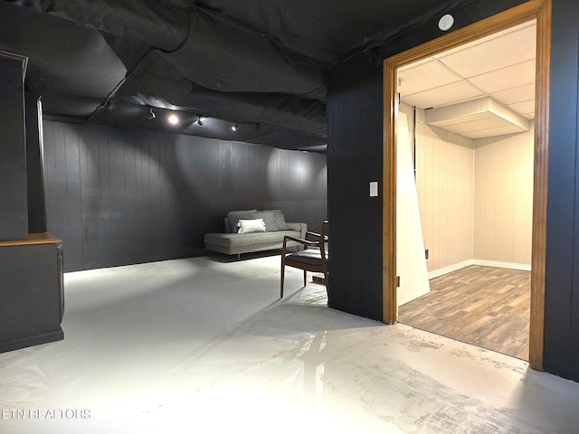 basement featuring hardwood / wood-style floors and wood walls