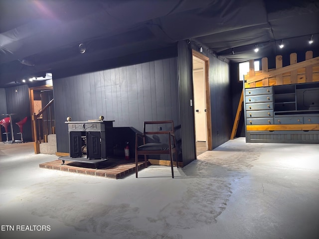 basement featuring a wood stove and wood walls