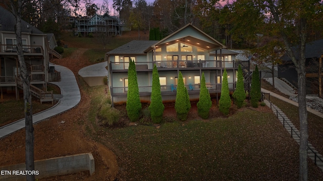 back house at dusk featuring a balcony