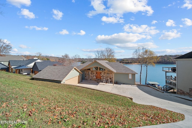 view of front of home with a front yard and a water view