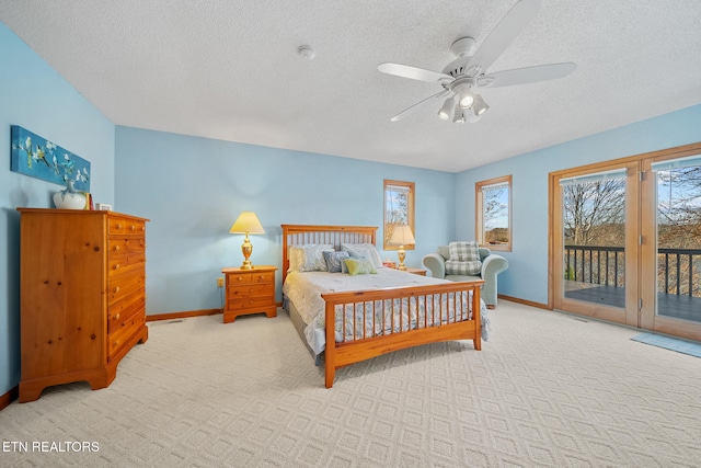 carpeted bedroom featuring access to exterior, a textured ceiling, and ceiling fan