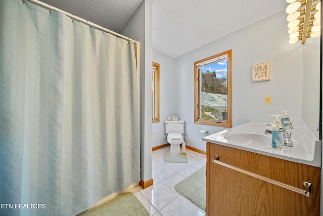 bathroom featuring tile patterned flooring, vanity, a textured ceiling, and toilet