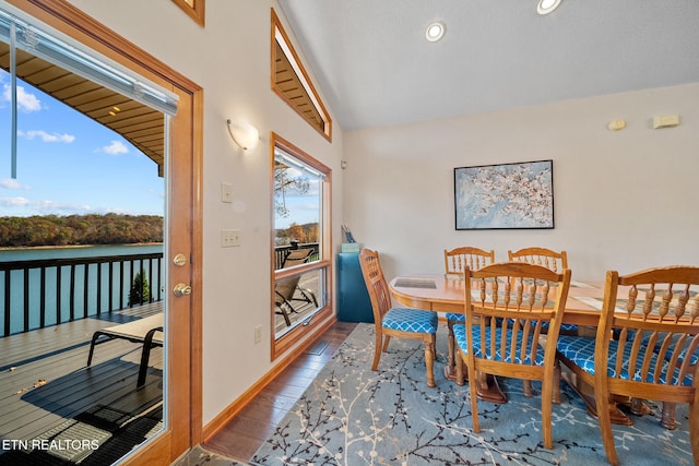 dining space with hardwood / wood-style floors, plenty of natural light, and lofted ceiling