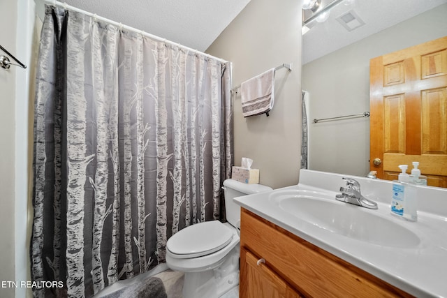 bathroom with toilet, vanity, and a textured ceiling