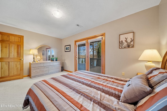 carpeted bedroom with access to exterior and a textured ceiling