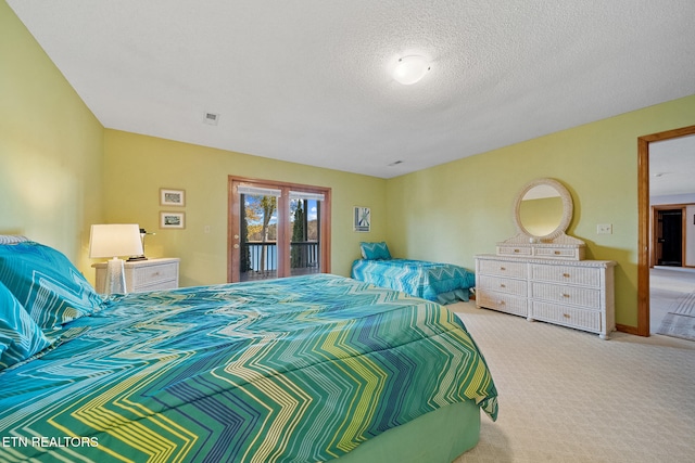 carpeted bedroom featuring a textured ceiling and access to exterior