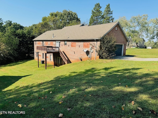 back of property with a garage, a wooden deck, and a yard