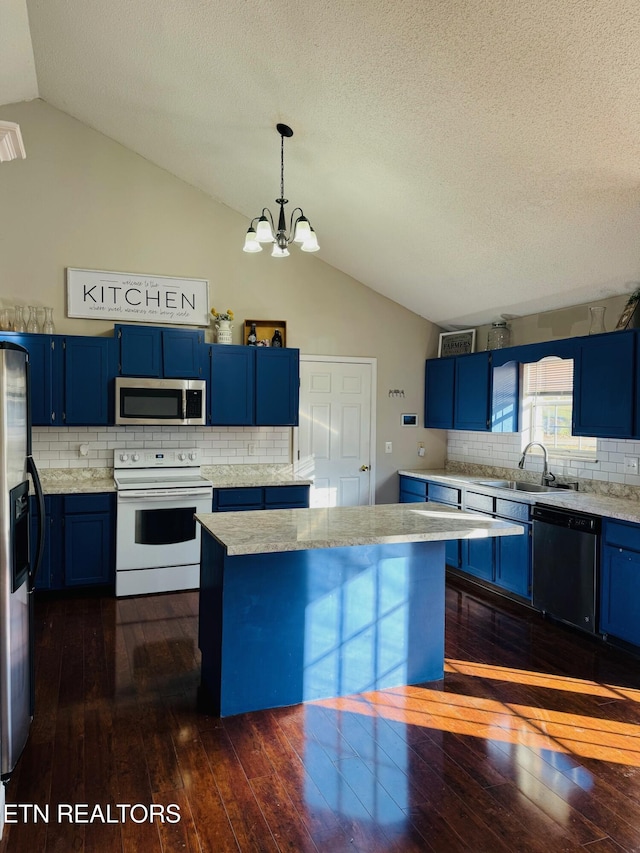 kitchen featuring dark wood-type flooring, blue cabinetry, hanging light fixtures, and stainless steel appliances