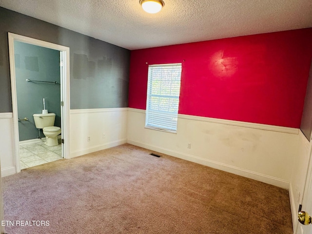 carpeted spare room featuring a textured ceiling