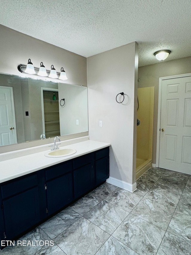 bathroom with vanity, a textured ceiling, and a shower