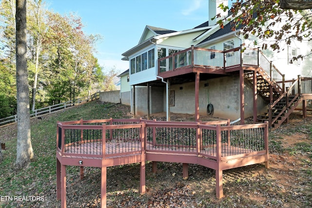 rear view of house with a sunroom and a wooden deck