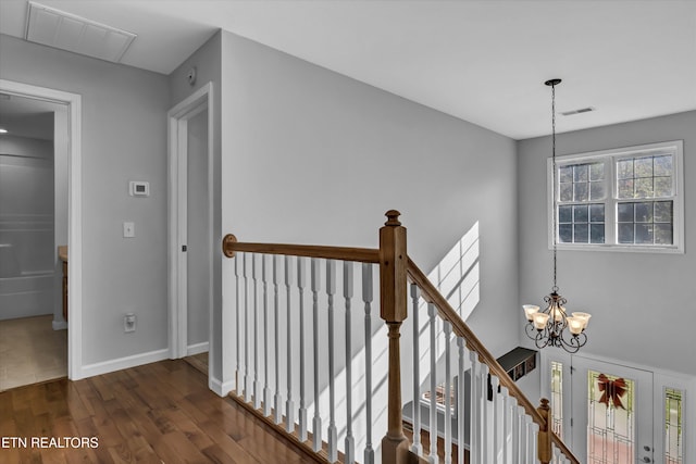 hallway featuring dark hardwood / wood-style floors and an inviting chandelier