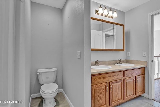 bathroom with tile patterned flooring, vanity, and toilet