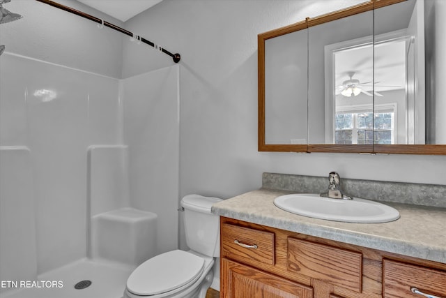 bathroom with ceiling fan, toilet, a shower, and vanity