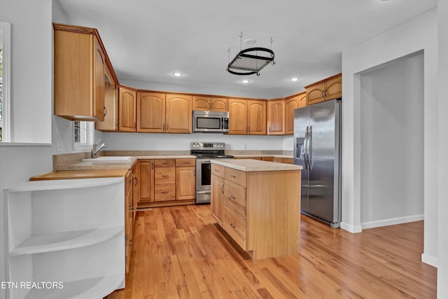 kitchen featuring a center island, light hardwood / wood-style floors, sink, and appliances with stainless steel finishes