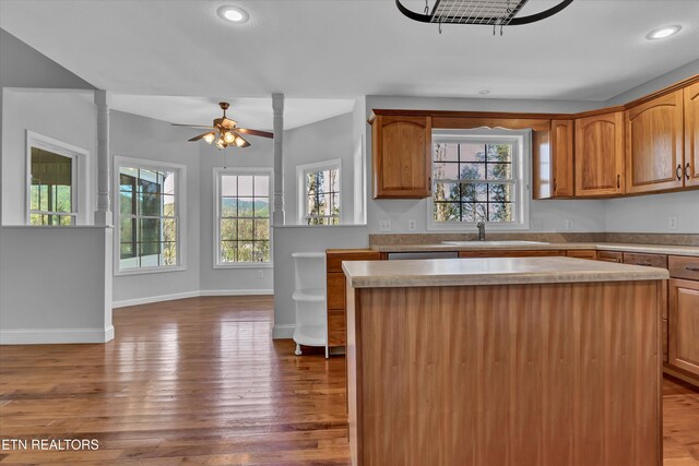 kitchen featuring hardwood / wood-style floors, a kitchen island, ceiling fan, and sink